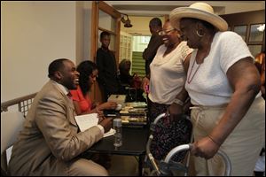 Kwame Kilpatrick laughs with Audrey Johnson, second from right, and her mother, Mantle Smith, both of Toledo, as he signs an autograph in his book 'Surrendered … The Rise, Fall and Revelation of Kwame Kilpatrick' at the Worship Center.