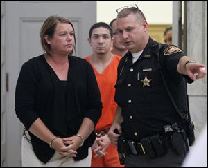 Kiki Lorann is escorted today from Wood County Common Pleas Court in Bowling Green, following her arraignment. The Perrysburg woman is charged with stealing nearly $100,00o from three civic organizations.
