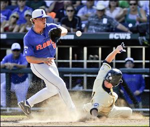 Kent State's Jimmy Rider scores on a wild pitch from Florida's Jonathon Crawford, left, in the fourth inning.