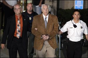Former Penn State University assistant football coach Jerry Sandusky, center, leaves the Centre County Courthouse in custody with Centre County Sheriff Denny Nau, left, after being found guilty of multiple charges of child sexual abuse in Bellefonte, Pa., Friday. Sandusky was convicted of sexually assaulting 10 boys over 15 years, accusations that had sent shock waves through the college campus known as Happy Valley and led to the firing of Penn State's beloved Hall of Fame coach, Joe Paterno.