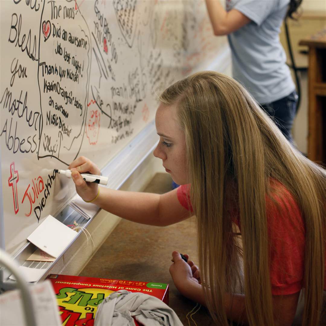 Cast-member-Julia-Dieckhoner-signs-a-white-board