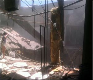 A woman checks out the damage after a roof collapsed at the Algo Centre Mall in Elliot Lake, Ontario, Saturday.