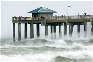 Waves crash against the Okaloosa Island Fishing Pier in Fort Walton Beach, Fla. as wind, waves, and storm from Tropical Storm Debby pound the Florida panhandle Sunday, June 24, 2012. Louisiana's governor declared a state of emergency as the storm threatens to flood low-lying coastal areas.