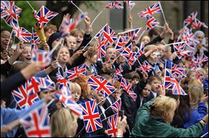 Schoolchildren wave Union Jack flags as they cheer on the Torchbearers in Wakefield, England during Day 38 of the London 2012 Olympic Torch Relay Monday.