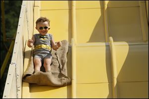 Caden Brown, 2, of Lambertville, enjoys the trip down a tall slide during the Bedford Summerfest at Parmelee Park in Lambertville.