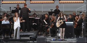 Sarah McLachlan, left, sings with her band and an orchestra.