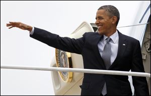 President Barack Obama waves as boards Air Force One