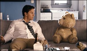 Mark Wahlberg, left, chats with Ted, voiced by Seth MacFarlane in a scene from ‘Ted.’