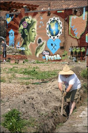 Curtis Osmun digs a trench to be used to place a pipe for irrigation for the community garden. The garden, the result of collaboration, is used as an outdoor classroom and art space. 