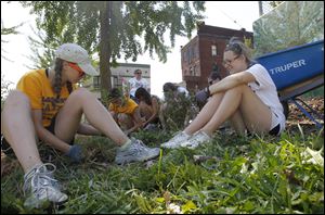 Georgia Cleary, left, and Olivia Jones work in the garden. The location not only has been planted with fruits, flowers, and vegetables, it serves as a bird study site for Cornell. 