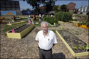 Manos Paschalis stands in in Manos Community Garden in the UpTown neighborhood. Mr. Paschalis initially wanted a farmers market like the one in downtown Toledo, but the idea grew into a garden.