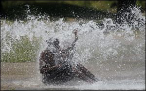 A fire hydrant opened at Walnut and Michigan streets in central Toledo provides relief from the record heat. Police opened some of the hydrants in the city where residents don't have ready access to a pool. 