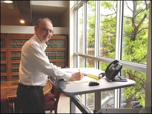 David Zoll works at his treadmill desk from Lifespan in his Toledo office.