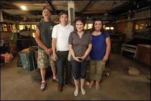 Deacon Tony Brister, left, Pastor Dan Stevenson, homeowner Deborah Smith, and April McGuire gather in Mrs. Smith's garage, which is to be organized as part of the volunteer project today.  Mrs. Smith's home is the initial site for the New Heights Fellowship Church's program.