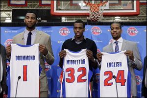 Pistons draft choices Andre Drummond, Khris Middleton, and Kim English hold up their new jerseys after being introduced by the team in Auburn Hills, Mich. Drummond was the ninth pick overall.