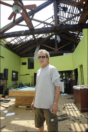 Dave Marshall assesses the damage to his home in Findlay. The former church lost its roof Friday.