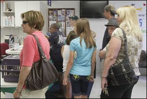 Libby Ziegler, left, of Toledo arrives at the Toledo Humane Society to adopt a pair of kittens as part of the humane society’s
$5 Fridays promotion to encourage adoptions. The special deal was for June, but the shelter is weighing the option of repeating it.