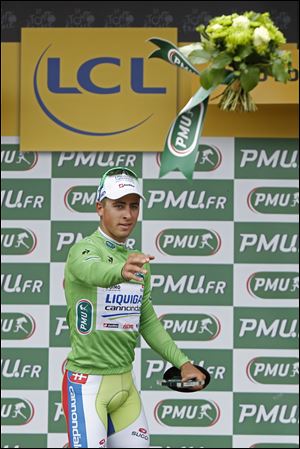 Stage winner Peter Sagan of Slovakia, wearing the best sprinter's green jersey, throws flowers to fans on the podium of the third stage of the Tour de France cycling race over 197 kilometers (122.4 miles) with start in Orchies and finish in Boulogne-sur-Mer, northern France Tuesday.