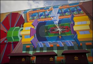 A mural at the European Center for Nuclear Research depicts how a Higgs boson, sometimes called the 'God particle,' may look. The subatomic particle could explain why matter has mass, which combines with gravity to give an object weight.