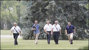 Law enforcement officers and firefighter personnel  go over the grounds in preparation for the President's visit.