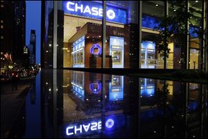 Automobiles pass JPMorgan Chase in New York City. The FDIC says fewer U.S. banks are at risk nationwide of failure for a variety of reasons: an improved economy, healthier loan portfolios, low interest rates, higher bank account fees, and a wave of mergers. 