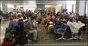 Dozens of travelers wait to board at Akron-Canton Airport in late June.
