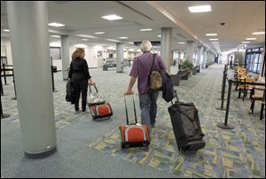 Susana Youngsteadt and her husband are among the passengers to trickle out of the gate after landing at Toledo Express in late June. The couple were on the West Coast when they learned they needed to get back because her mother was dying. The trip took several flight changes and 17 hours. 