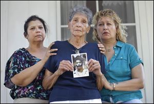 Flanked by daughters Diana Lerma, left, and Marta Rodriguez, Pauline Rodriguez holds a photo of Esaw Rodriguez, Jr., who vanished while hitchhiking.