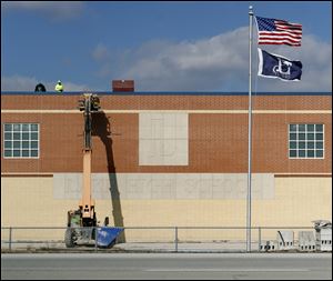 Workers raise materials to the roof of the new Lake High School, which is scheduled to open this fall. The previous school was among the many structures destroyed by the deadly tornado that struck in June, 2010.
