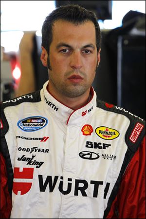 Sam Hornish Jr. stands in his garage stall during practice for the NASCAR Sprint Cup Series Coke Zero 400 auto race at Daytona International Speedway.