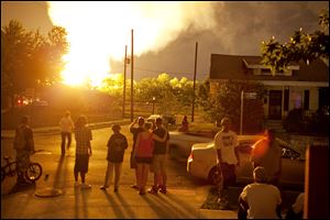 People watch the flames shoot up from a freight train that derailed in Columbus.