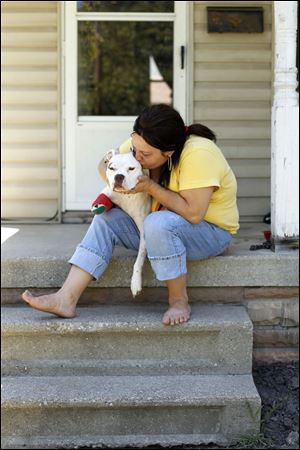 Renee Siefker holds Mamas in East Toledo. Gunfire struck Mamas in both front legs on June 30. She is scheduled for surgery.  