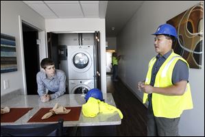Adam Radtke, UT student and leasing manager, left, shows grad student Glen Wang one of the 48 loft-style apartments above the shops. In addition to Barnes & Noble, stores will include a sandwich shop, a wireless-phone store, and a hair salon.