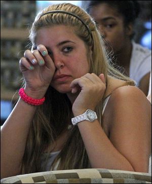 Penn State freshman Jessica Knoll of Lebanon, Pa., wipes a tear in the student HUB on the university's main campus in State College, Pa., as she listens to the televised news conference held by former FBI Director Louis Freeh. The news conference was held after the release of his group's report on the Jerry Sandusky child sex abuse scandal.  