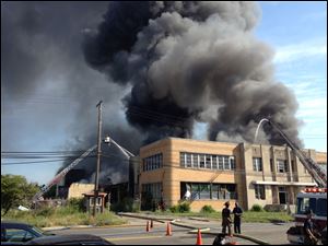 Smoke billows from the 100,000-square-foot Sanders Confectionery complex in Highland Park, Mich. The fire was under control by late Saturday morning.