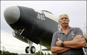 Former space shuttle worker Terry White poses in front of a mock space shuttle at the Astronaut Hall of Fame in Titusville, Fla. White was a project manager who worked 33 years for the shuttle program until he was laid off after Atlantis landed last July 21. 