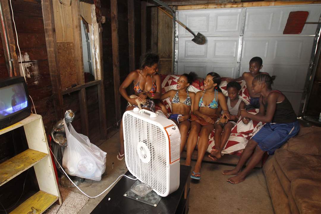 Teens-and-youngsters-huddle-in-front-of-a-fan