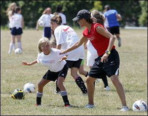 Former Olympian Tisha Venturini-Hoch checks the stance of
Peyton Starner, 11, of Temperance during the TeamFirst Soccer Academy at the University of Toledo.