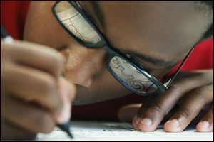 Andre Smith, 12, of Sylvania, traces his pencil drawing with precision Friday afternoon during a session of Lourdes University's three week art camp.