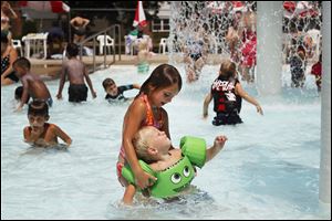 Margaret O'Neill, 6, holds her brother Finnegan, 2, as they cool off at Burnside Park in Sylvania. All of Ohio was under a severe weather alert for heat on Tuesday.