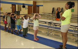 Melissa Avalos, right, site coordinator of the summer program at Reynolds Elementary, plays ‘Simon Says’ with several kids including Elysa Oman, front of line, Jashon Garrett, and Victor Vasquez.
