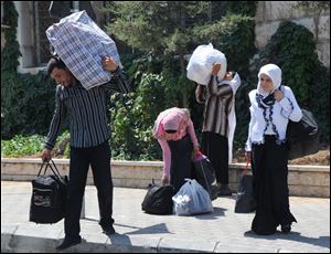 Syrians cross into Lebanon at Masnaa, about 25 miles from Damascus. Refugees arrived at the border Friday in buses, taxis, and private cars, joining the flood who have fled in the last 48 hours. 