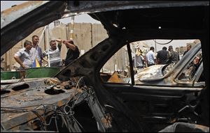 People gather at the scene of a bomb attack in Baghdad's Shiite enclave of Sadr City, Iraq.