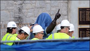 Workers covered the statue of former Penn State football coach Joe Paterno prior to taking it away. About 50 fans watched the actual removal Sunday morning.