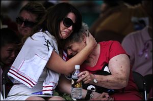 Family members of the victims of the Century 16 theater shooting remember their loved ones during a vigil at the Aurora Municipal Center campus in Aurora, Colo.