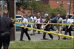 Members of the prosecution team arrive at the apartment complex where accused shooter James Holmes lived. Meanwhile, a judge ruled Tuesday to bar TV cameras from the suspect's next court appearance.