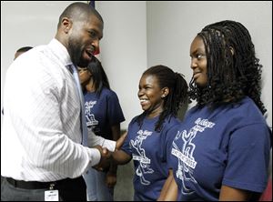 JoJuan Armour, prevention supervisor at the Urban Minorities Alcoholism and Drug Abuse Outreach Program of Lucas County, congratulates Kyrha Benson, center, and Shanyah Owens, both 15.