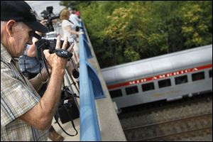 Jim Bradford, 84, of Redford Township in suburban Detroit, films the Nickel Plate Road 765 steam locomotive during its excursion from Oregon to Maumee. The steam engine is set to make two more trips between Oregon and Maumee beginning at 11 a.m. today. 