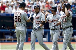 Detroit Tigers shortstop Jhonny Peralta, second from left, celebrates a three-run home run with, from left, Brennan Boesch, Ryan Raburn, and Delmon Young against the Toronto Blue Jays during the second inning on Sunday in Toronto. The Tigers won 4-1.