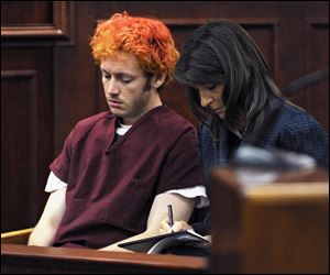 Public Defender Tamara Brady, right, takes notes as James E. Holmes appears in Arapahoe County District Court last Monday.